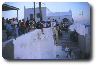 Turister samlas i Oia inför solnedgånen
