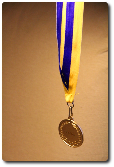 En guldmedalj är en symbol och ett pris för en ...